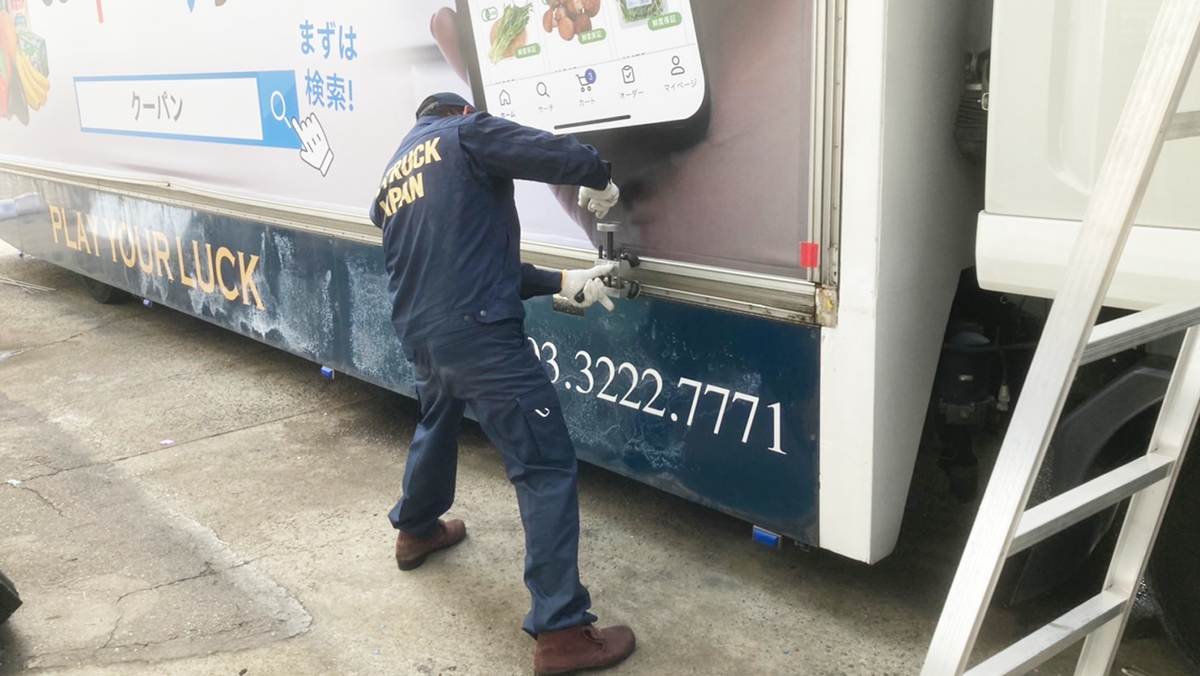 広告トラックの広告面施工風景